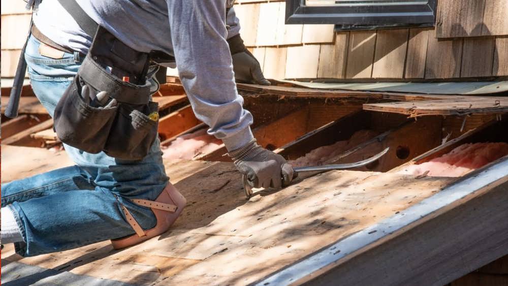 مرد سقف کار در حال برداشت سقف با دیلم